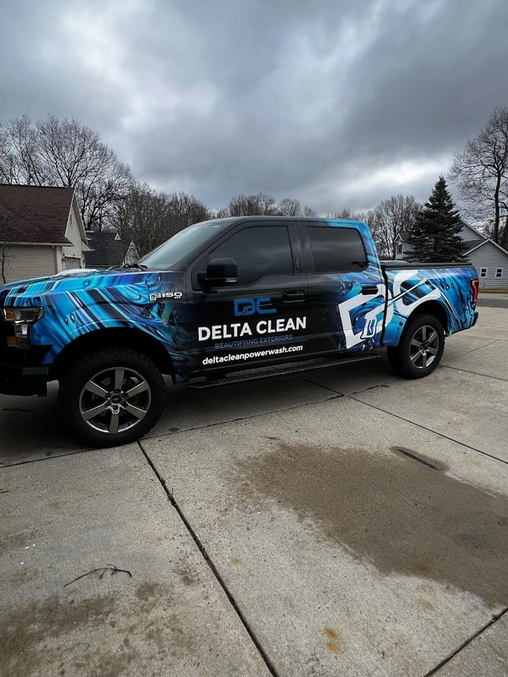 Delta Clean branded truck with blue graphics, parked in a residential area.